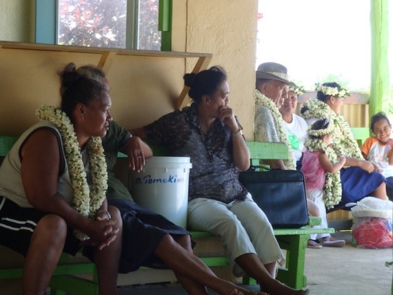 Locals waiting at Atiu airport, adorned with Ei Kaki (flower garlands).