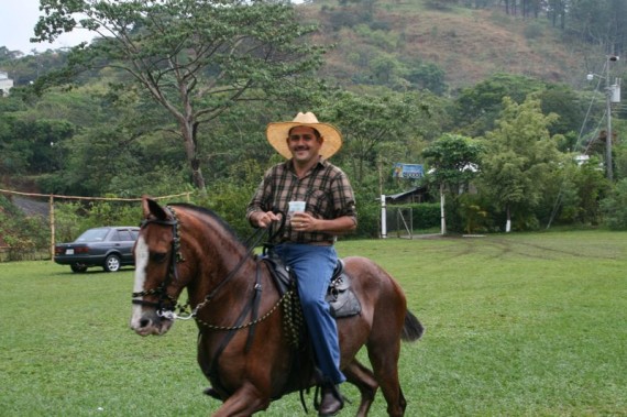 Costa Rican cowboy drinking on horse back Costa Rican cowboy drinking on horse back