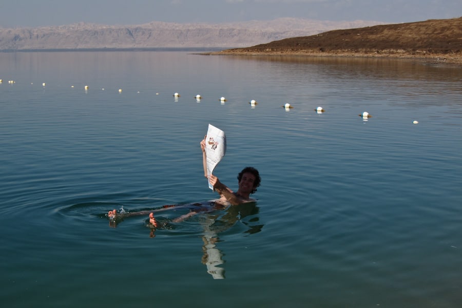 Simon reading a newspaper in the Dead Sea, Jordan