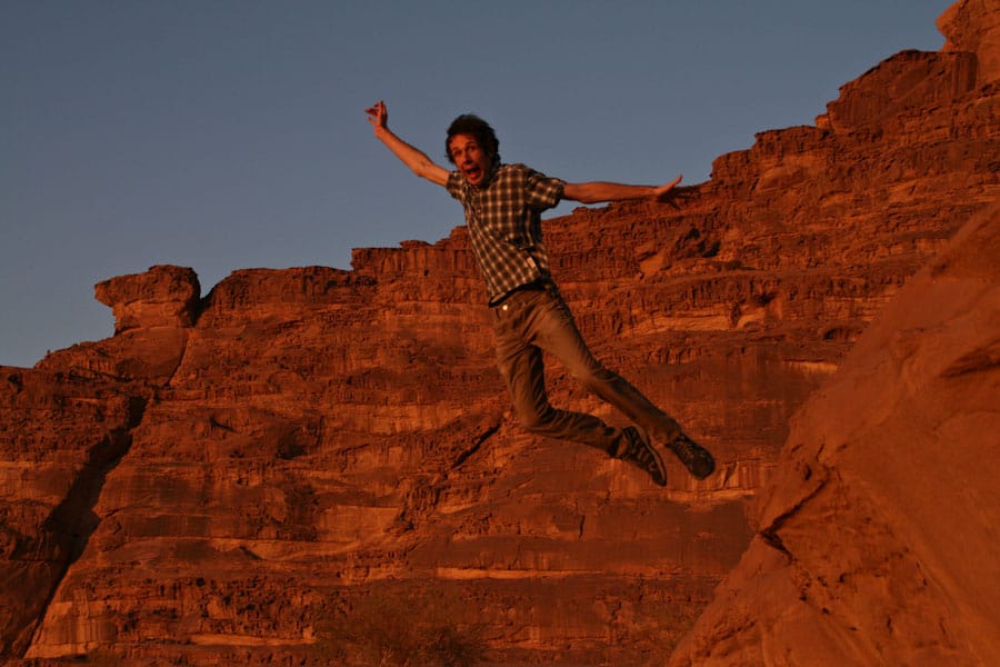 Simon jumping off the rocks at Wadi Rum