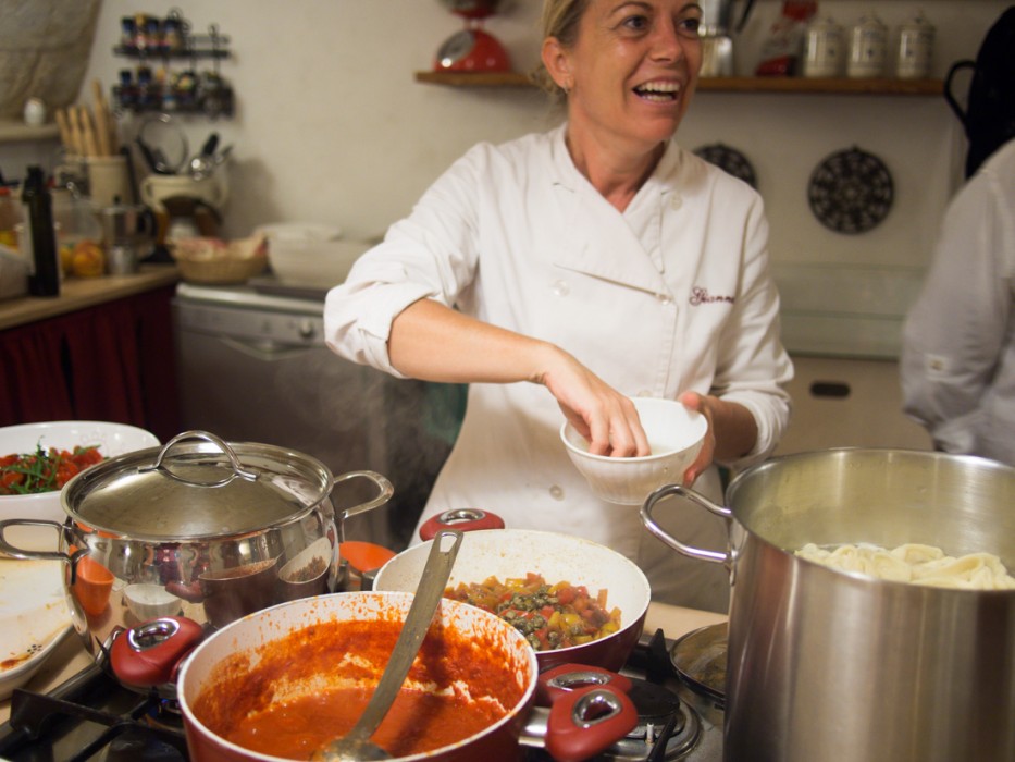 Gianna adding capers to the peperonata