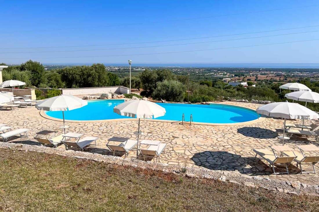 The pool at Masseria Spetterata in Puglia with a view of the Adriatic Sea and olive groves. 