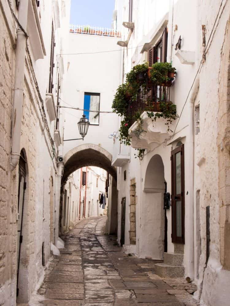 Narrow street with archway in Ostuni old town, Puglia, Italy