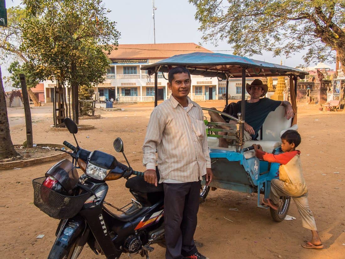 Simon in a tuk tuk with our driver Kim San and a random kid