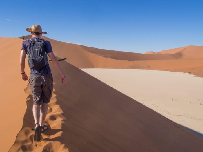 Hiking up sand dunes in Namibia with the Gonex ultralight backpack, one of the best packable daypacks
