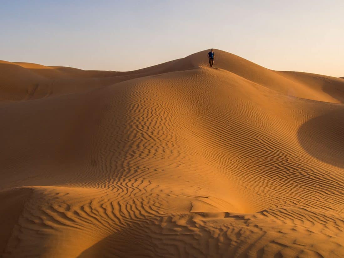 Simon walking along the rolling sand dunes at Wahiba Sands, Oman