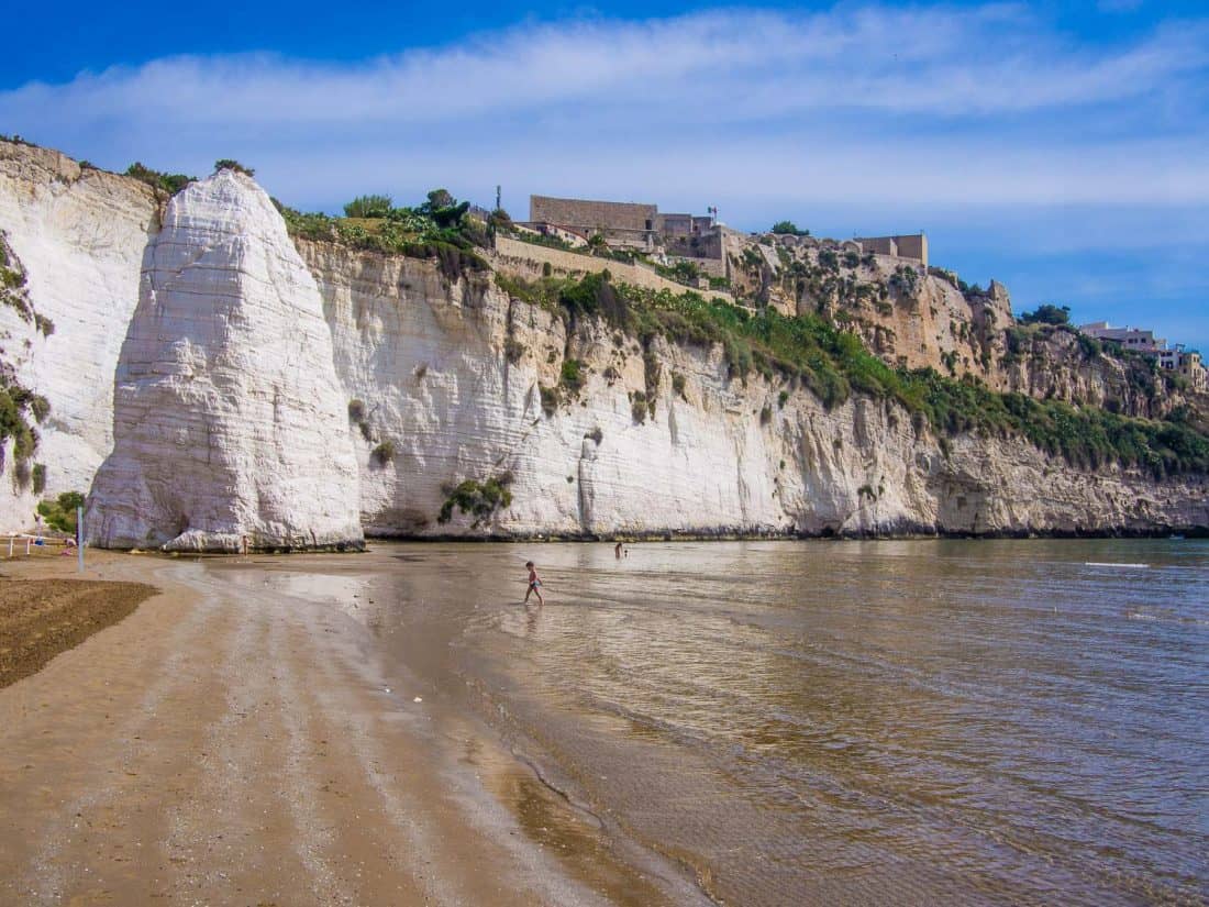 Pizzomunno rock at the end of Castello beach and the castle just above it in Vieste Puglia in southern Italy