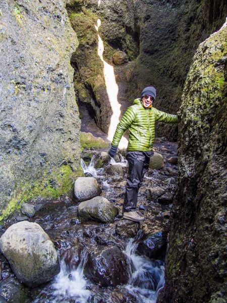 Iceland packing list- Simon is wearing a down jacket, waterproof overtrousers, and hiking shoes in Rauðfeldsgjá Gorge