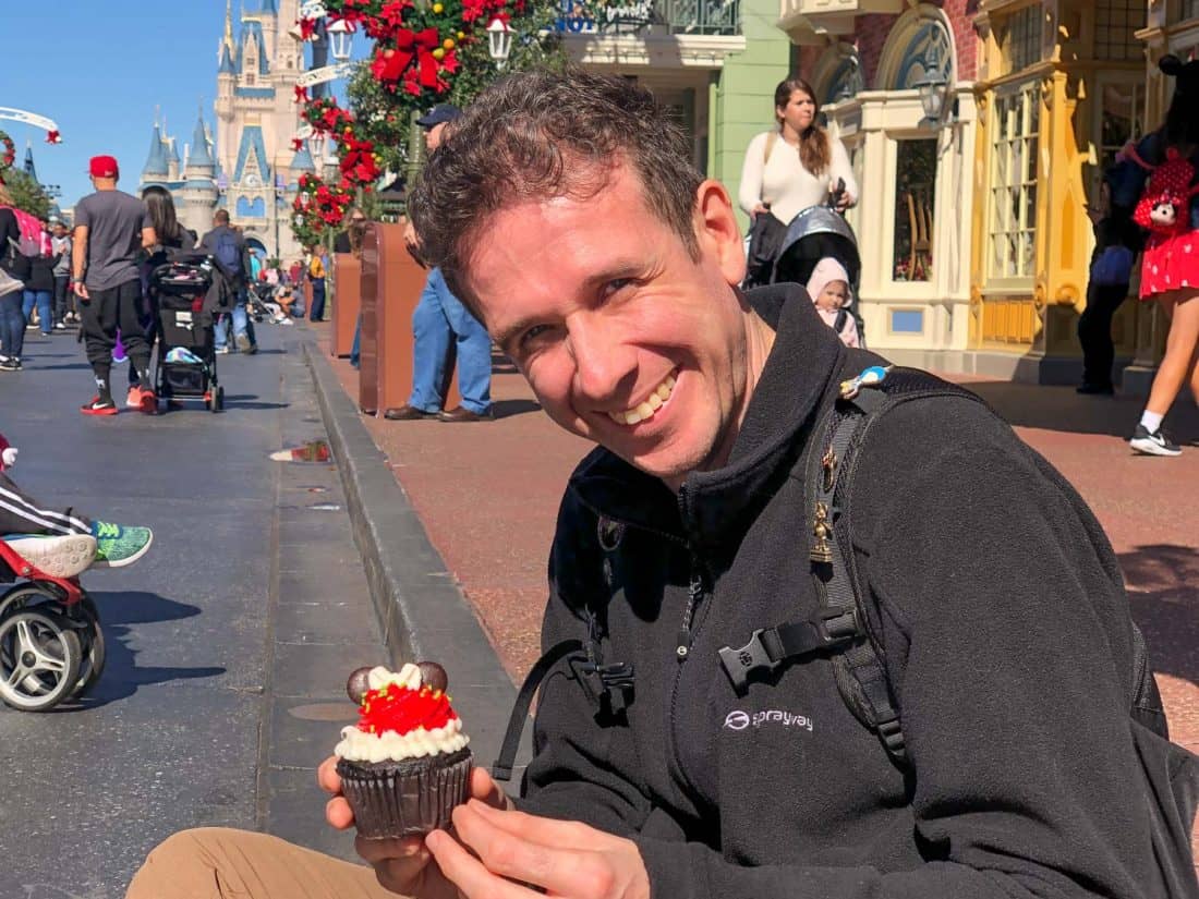 Simon eating a Mickey cupcake at Disney World Magic Kingdom Main Street