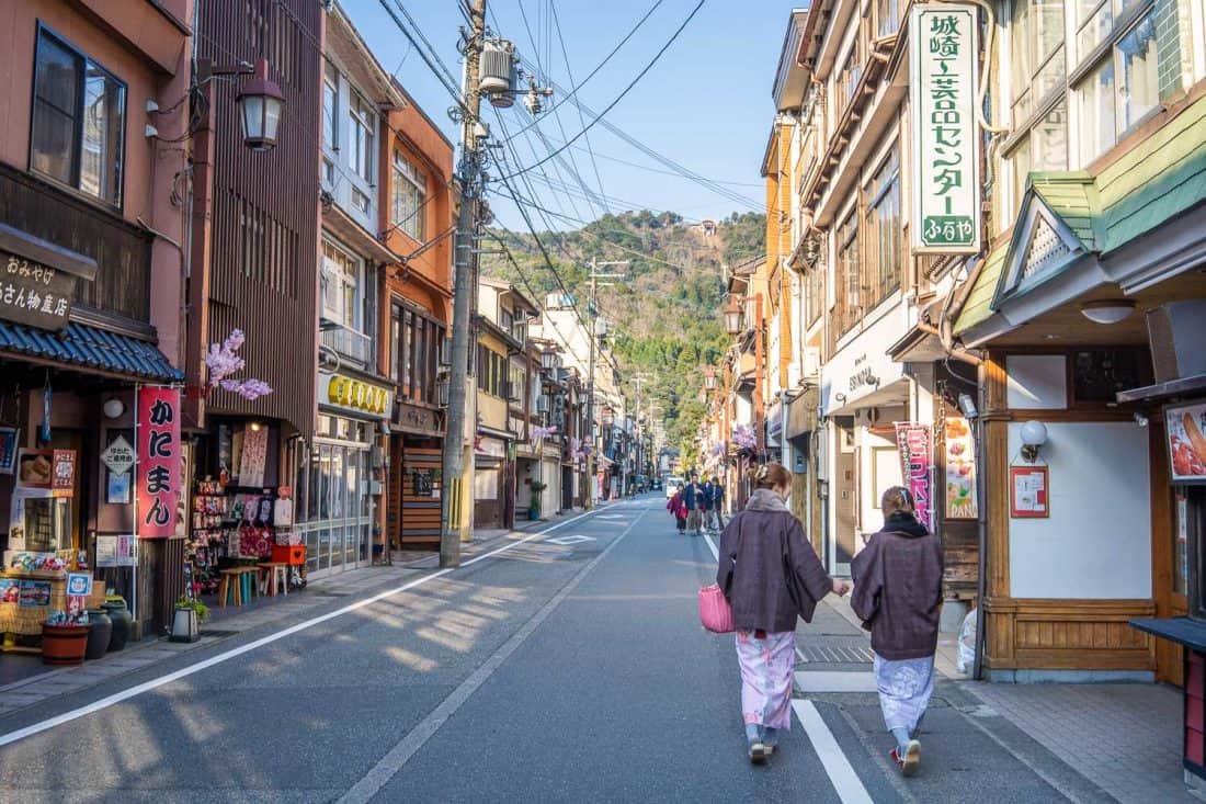 Visitors in kimono and geta walking down the main street of Kinosaki Onsen