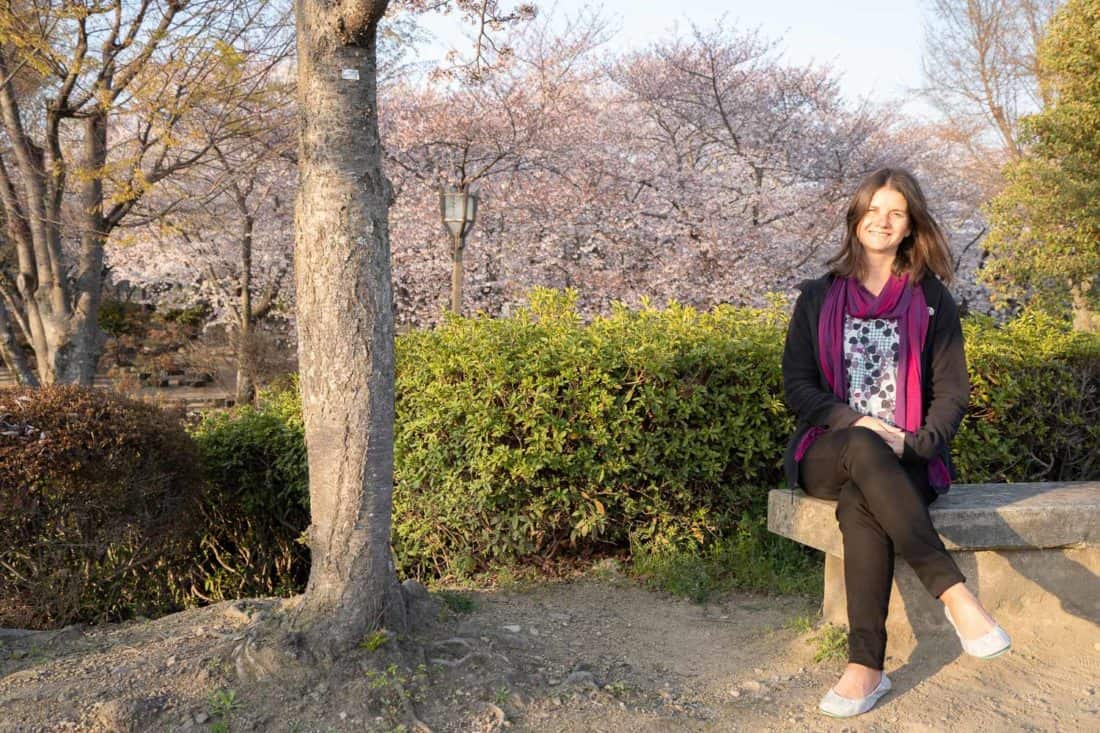 Erin wearing vegan Tieks in the cherry blossom gardens at Himeji Castle in Japan