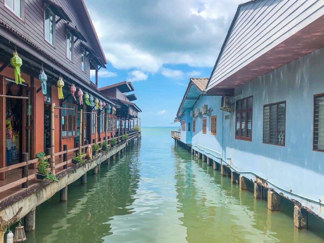 Blue and brown wooden houses on stilts over the water in Old Town on the East Coast of Koh Lanta, Thailand