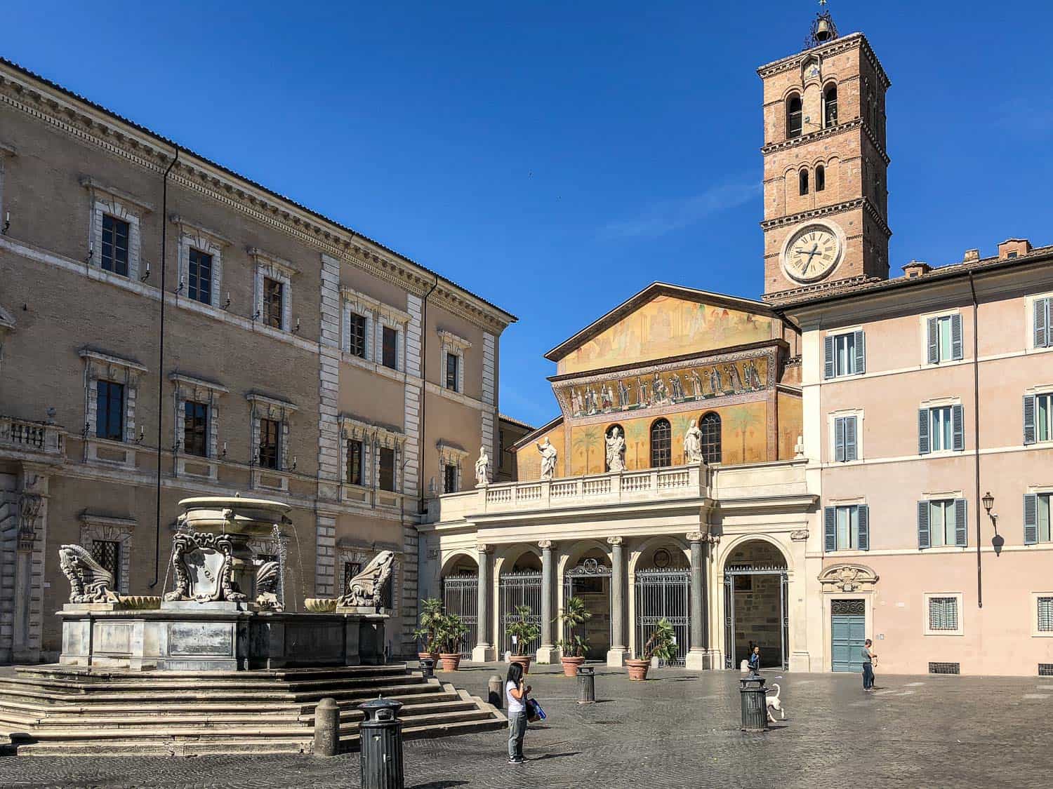Church and fountain in a quiet Piazza Santa Maria in Trastevere, Rome, Italy