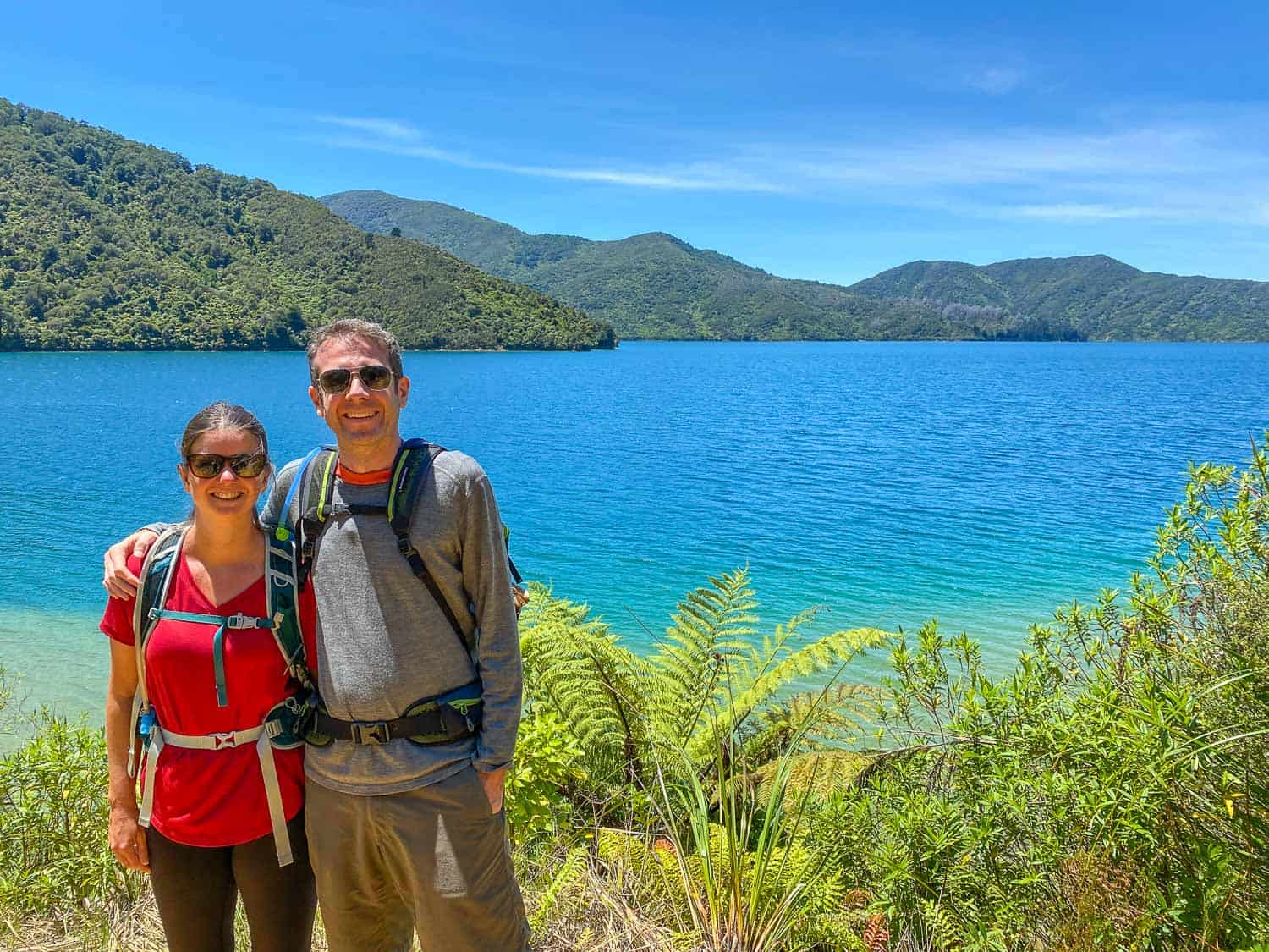 Erin and Simon on a sunny day walking the Queen Charlotte Track, New Zealand