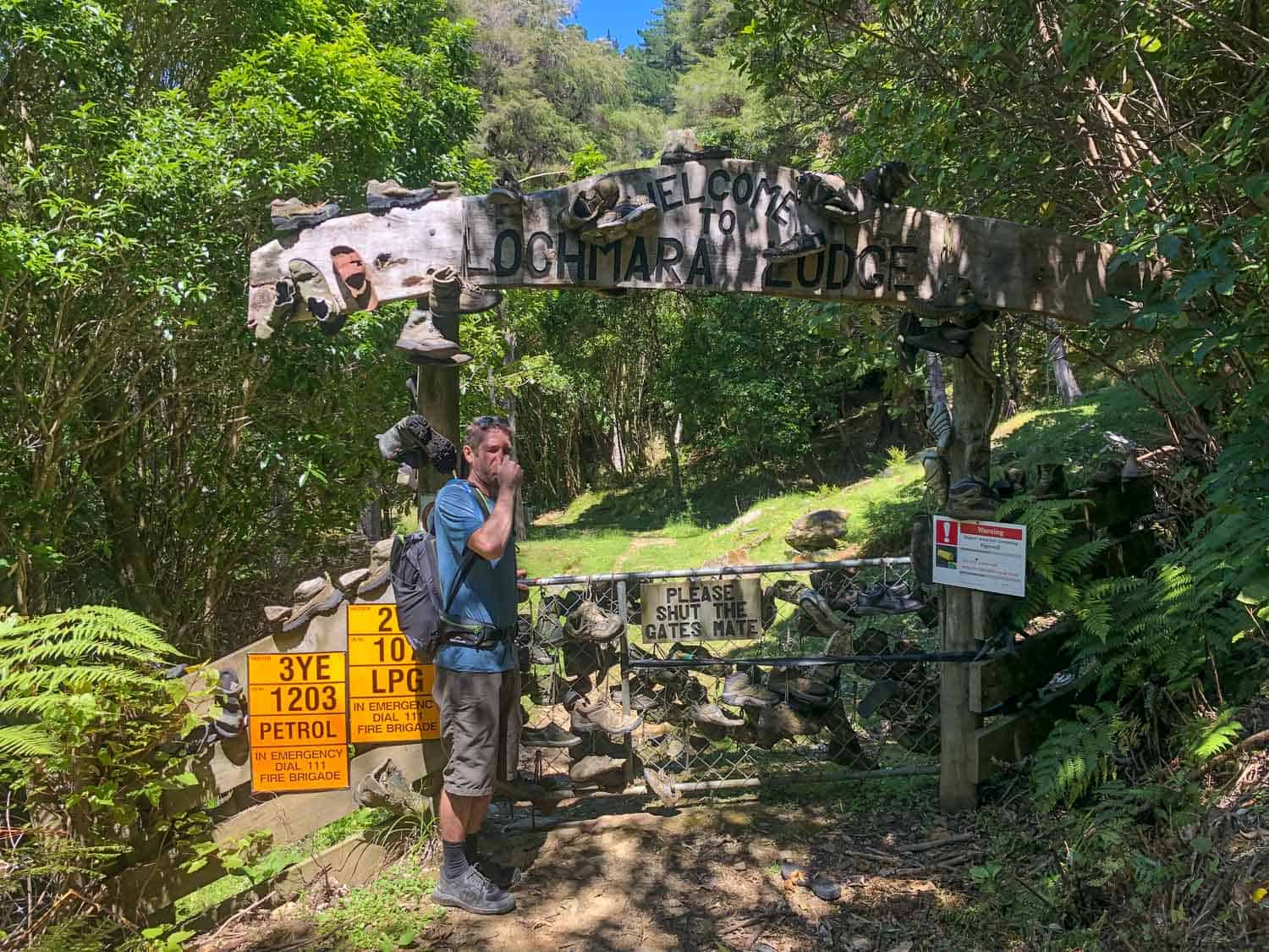 A gate covered in old boots at the entrance to Lochmara Lodge in the Marlborough Sounds, Queen Charlotte Track, New Zealand