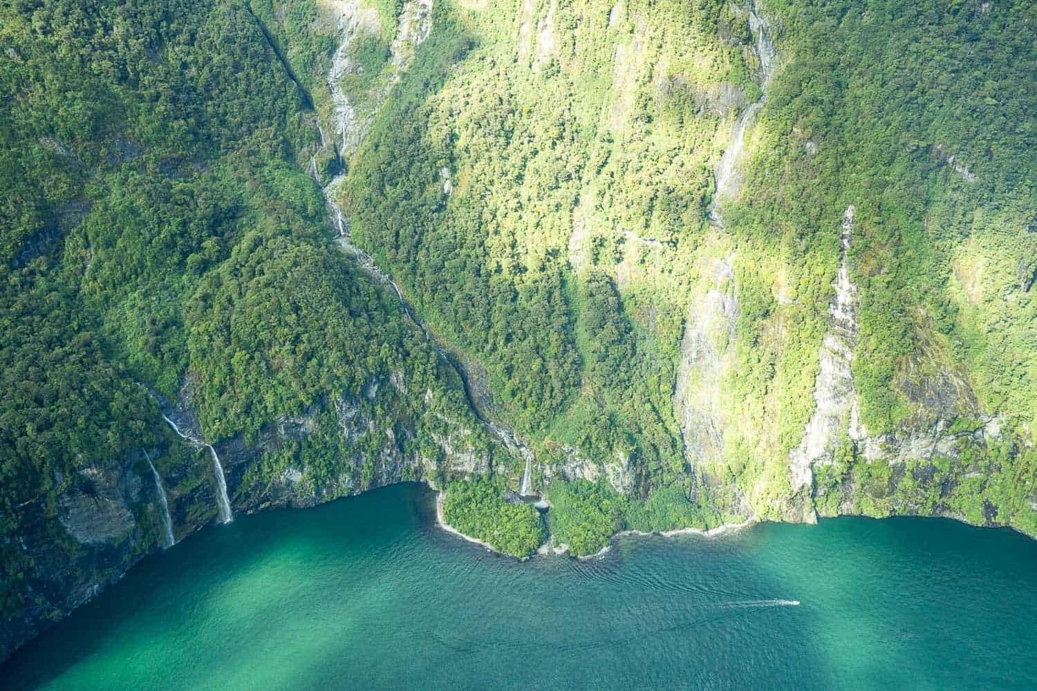 Flying above the waterfalls and cliffs of Milford Sound, New Zealand
