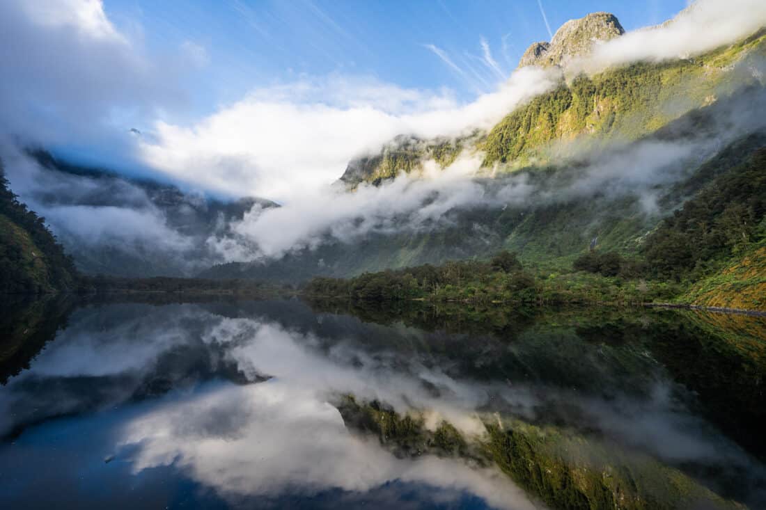 Early morning cloudy reflections on a Doubtful Sound overnight cruise in South Island New Zealand