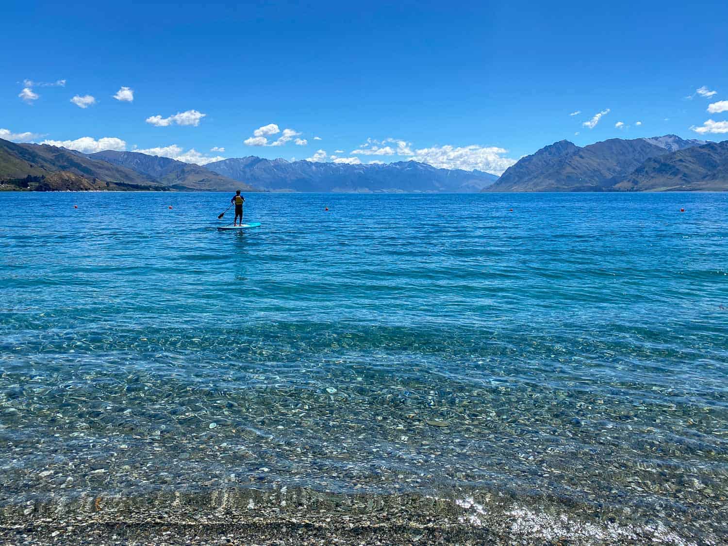 Simon stand up paddle boarding on Lake Hawea, Wanaka, New Zealand