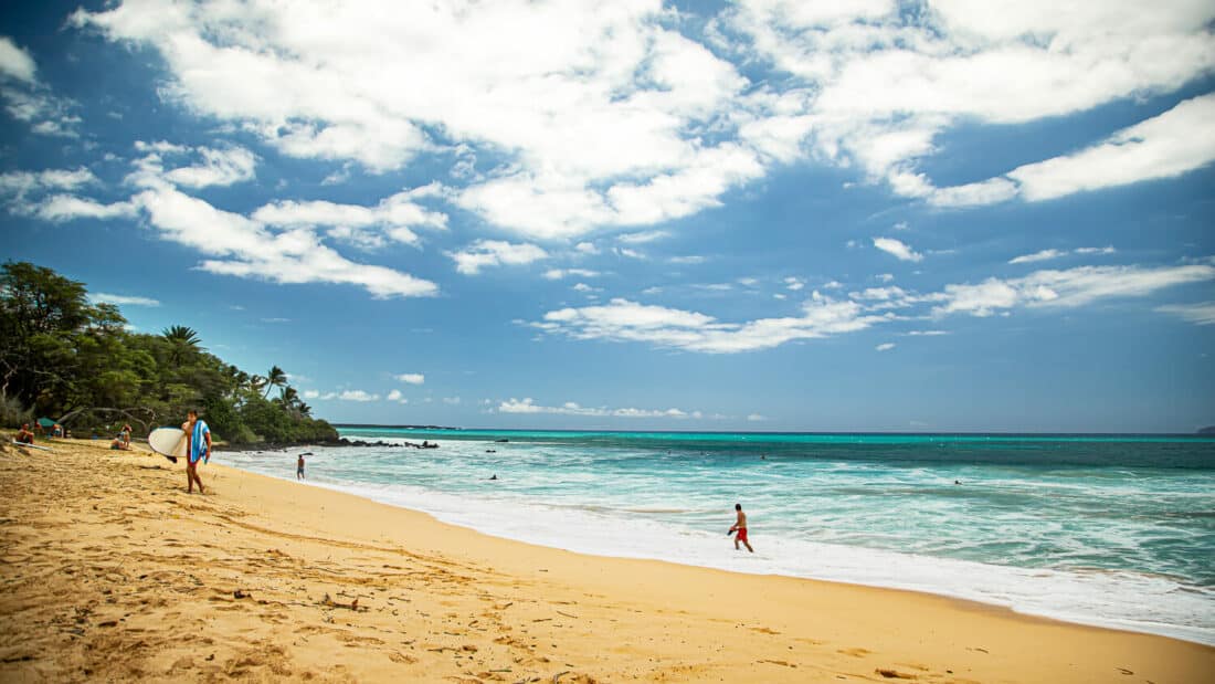 Surfer on the golden sands of Big Beach, Maui, Hawaii, USA