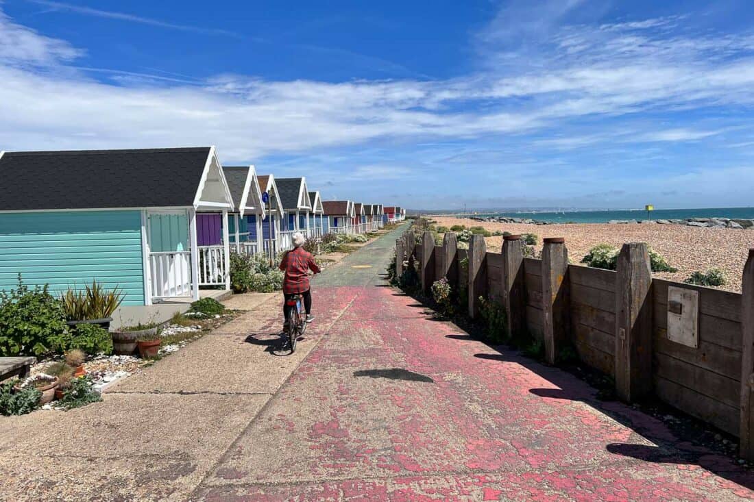 Cycling past colourful huts at Lancing, England