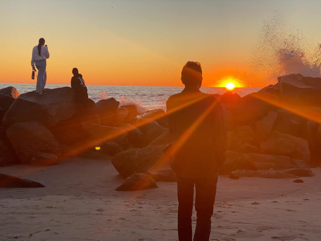 Sunset and crashing waves on the breakwater, Venice, Southern California