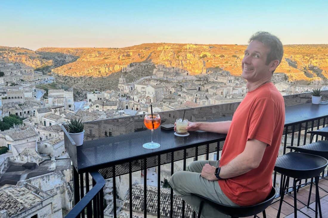 Simon with cocktails at Terrazza Cavaliere and a view of Matera sassi