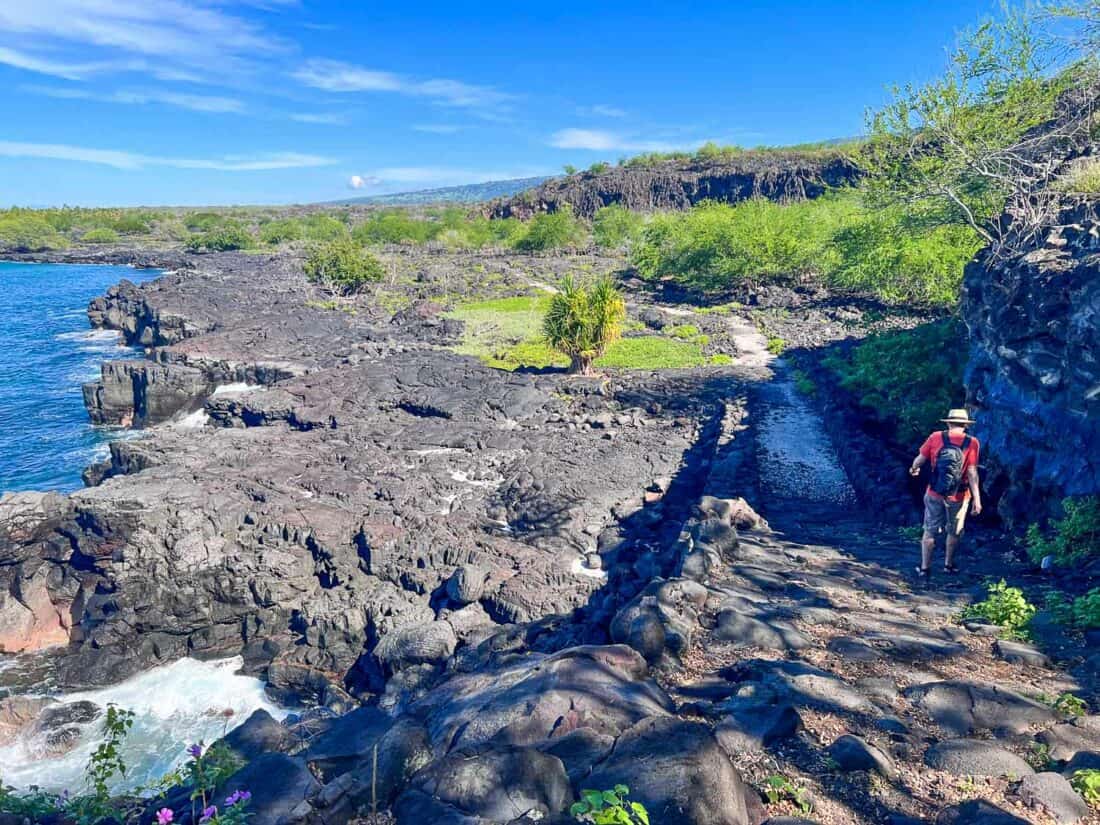 Simon hiking on the 1871 trail in Puʻuhonua o Hōnaunau, one of the best things to do on the Big Island Hawaii, USA