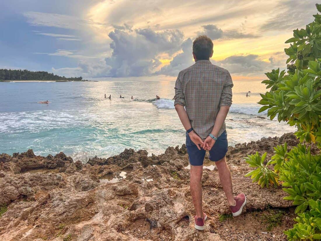 Simon watching surfers at sunset at Turtle Bay Resort in North Shore Oahu, Hawaii, USA