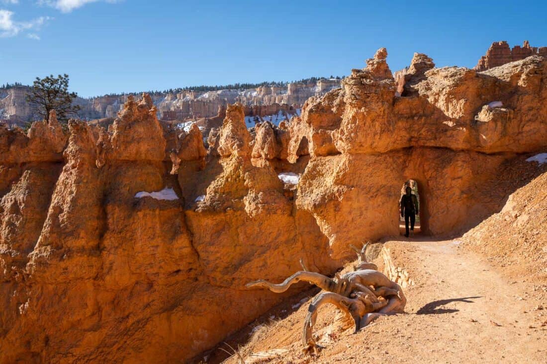 Walking through a rock arch on the Queens Garden Trail in Bryce Canyon National Park, Utah