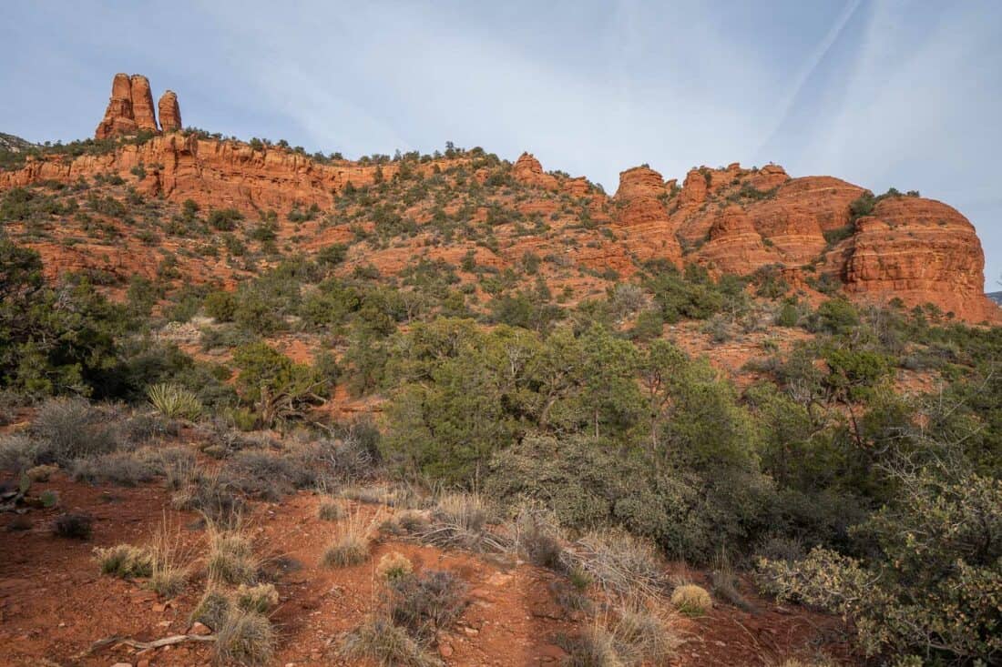 Red rock formation of Lower Chimney in Sedona overlooking trees and bushes below, Arizona, USA