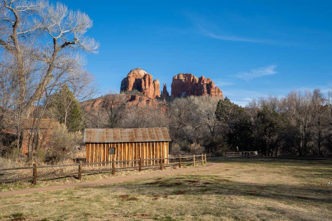 Paved path on the Oak Creek Trail in Sedona overlooked by the tall red craggy Cathedral Rock, Arizona, USA