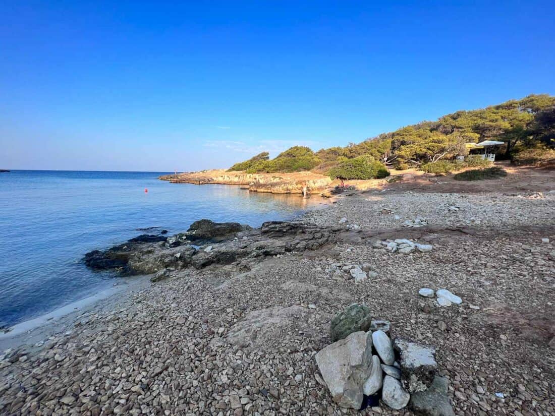 Pebbly Porto Selvaggio beach on a sunny blue sky morning