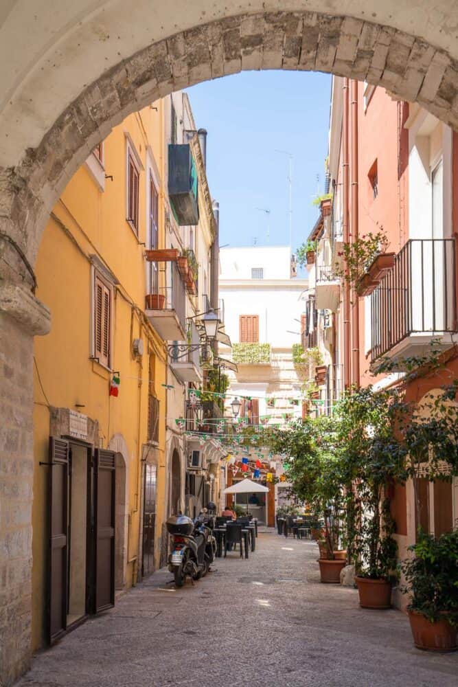 Street in Bari with archway and restaurants and colourful bunting, Puglia, Italy
