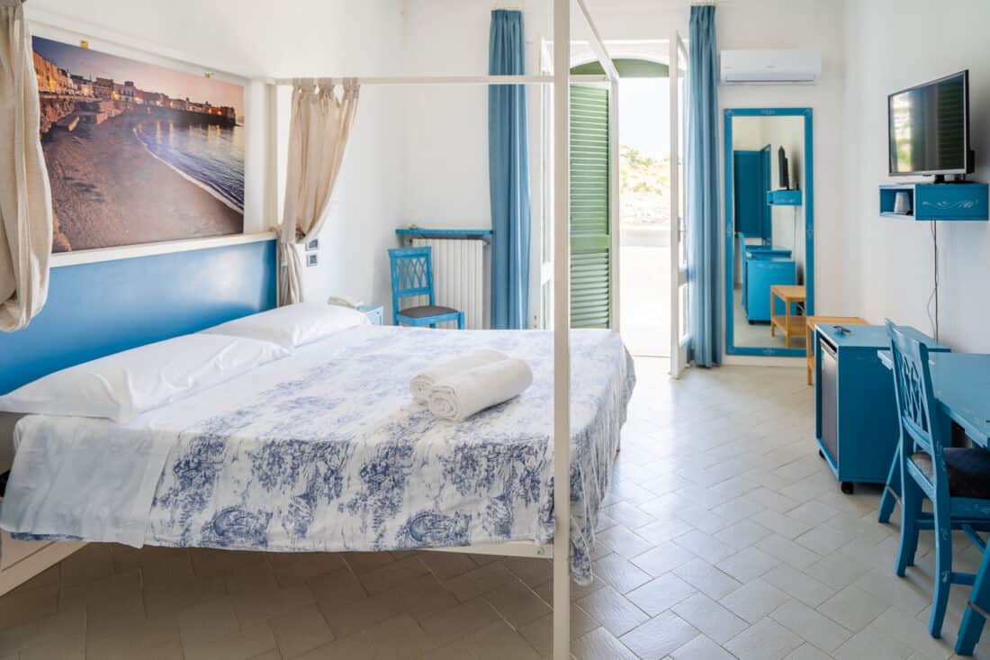 Double room with simple blue white decor at Hotel La Roccia, Castro, Italy