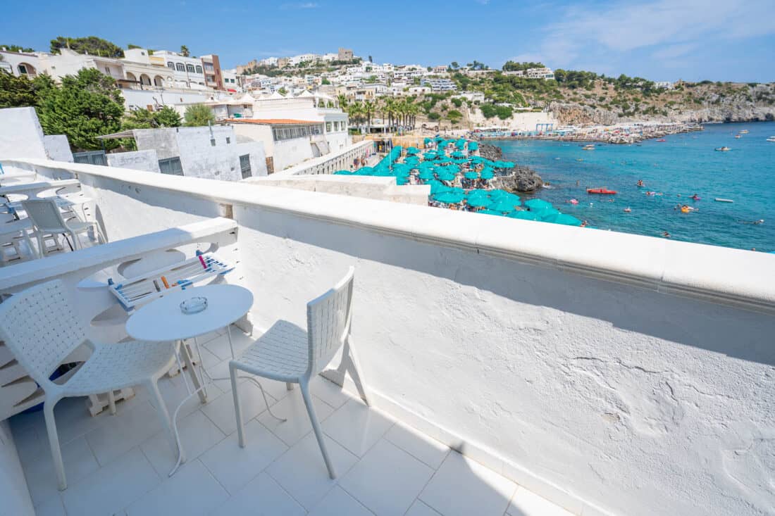 White Hotel Roccia balcony overlooking Castro's marina with turqoise parasols and clear blue waters