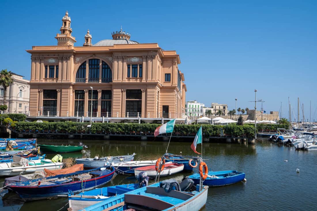 Pink facade of Teatro Margherita overlooking fishing boats in Bari, Italy