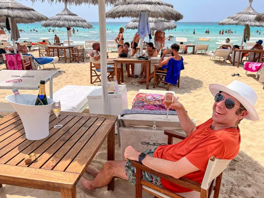 Simon with champagne dining on the beach at Bahia del Sol Porto Cesareo beach club in Torre Lapillo, Puglia.