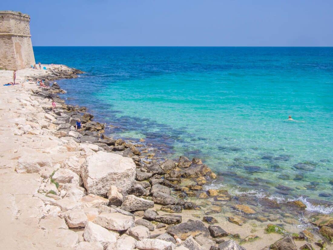 Rocky end of Monopoli Beach with turqoise clear waters, Puglia