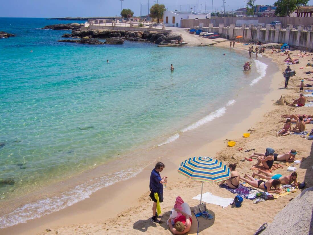 People relaxing on the small Cala Porta Vecchia Beach in Monopoli, Puglia