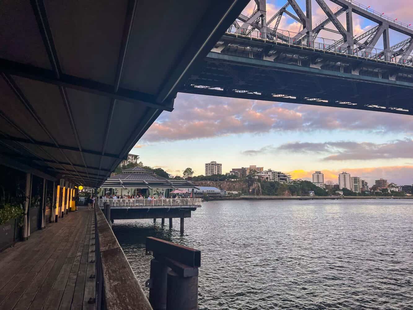 Restaurants and walkway going under Story Bridge at Howard Smith Wharves at sunset, Brisbane, Australia