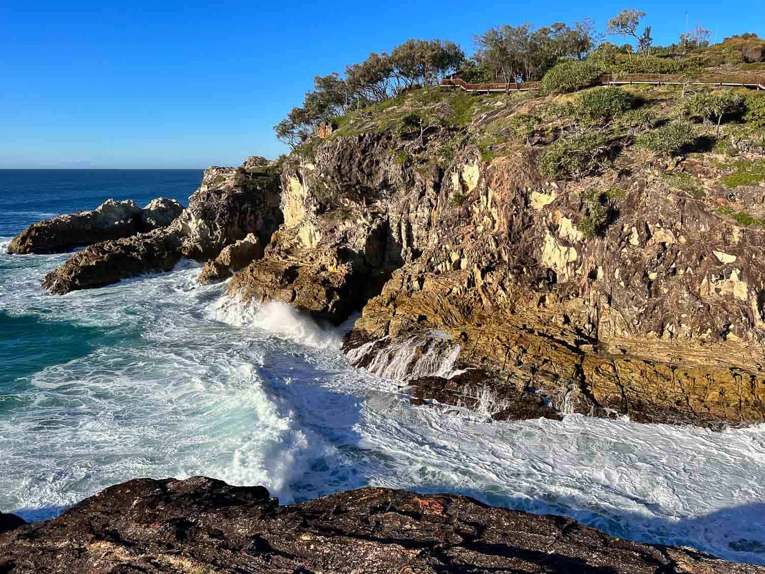 Crashing waves against rocky coves along North Gorge Walk, North Stradbroke Island, Queensland, Australia