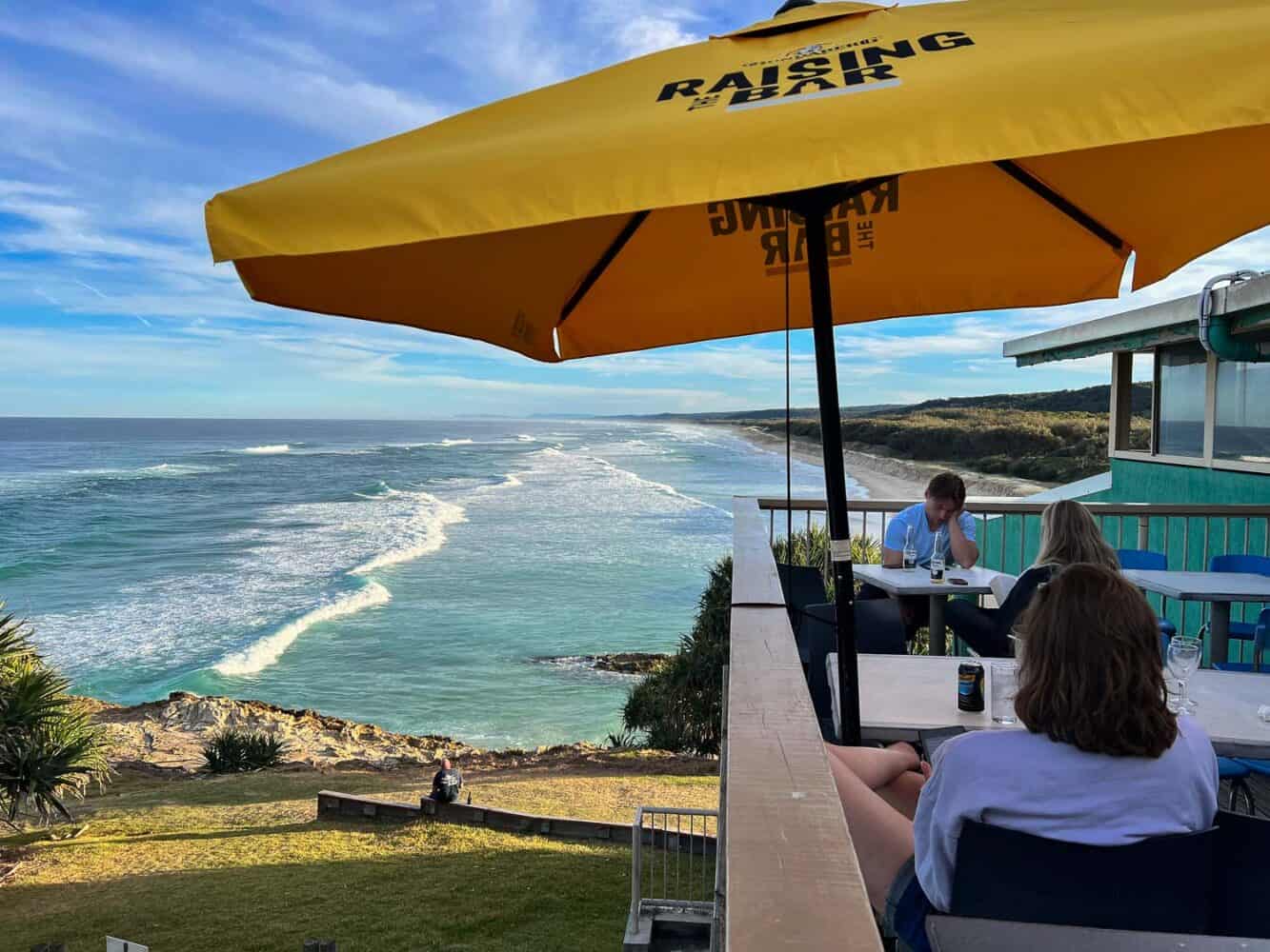 People relaxing on the balcony of Surf Life Saving Club overlooking Main Beach, North Stradbroke Island, Queensland, Australia