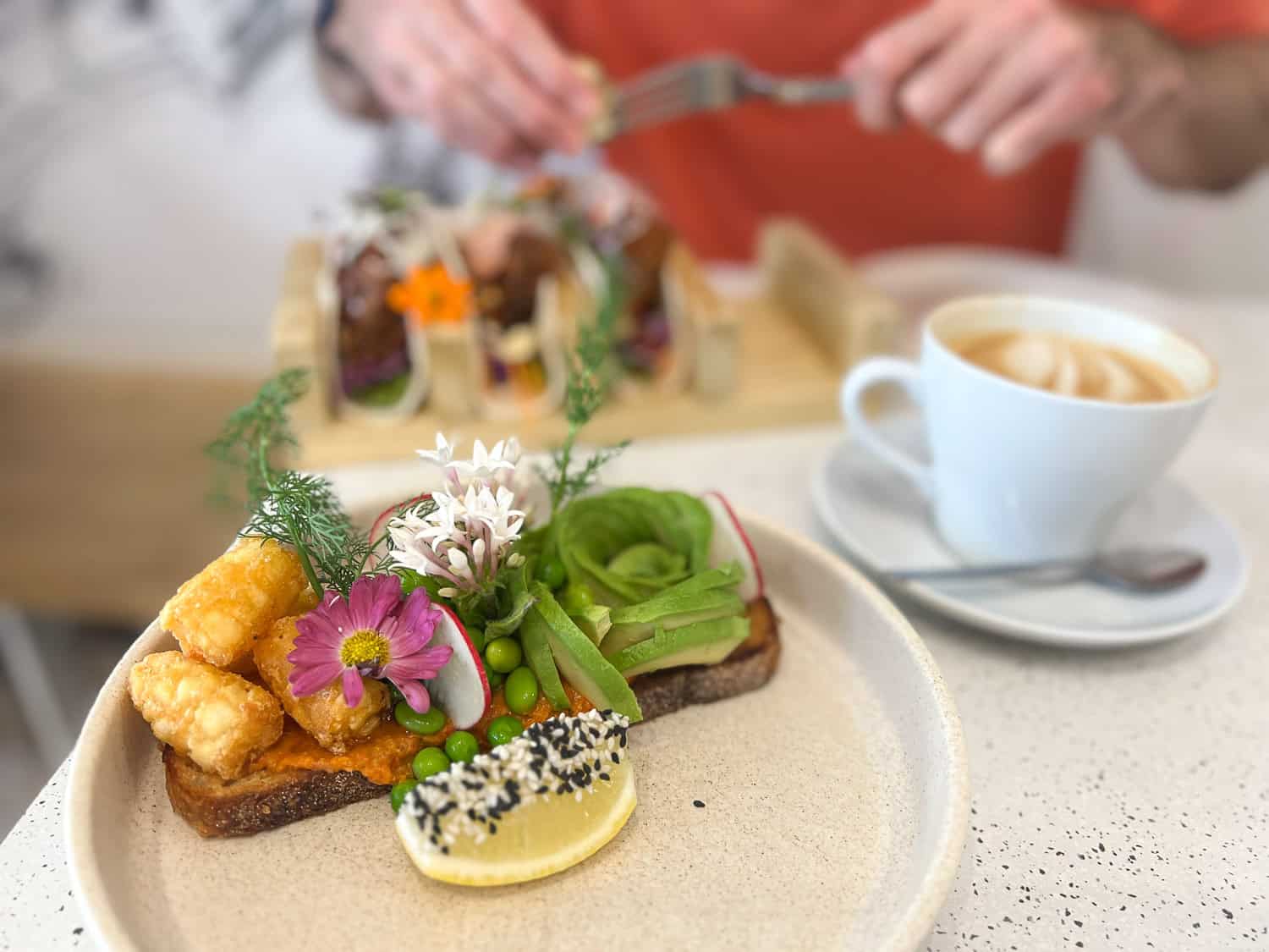 Prettily decorated avocado toast with hummus, edamame, potato gems at Lamkin Lane Espresso, Caloundra, Queensland, Australia