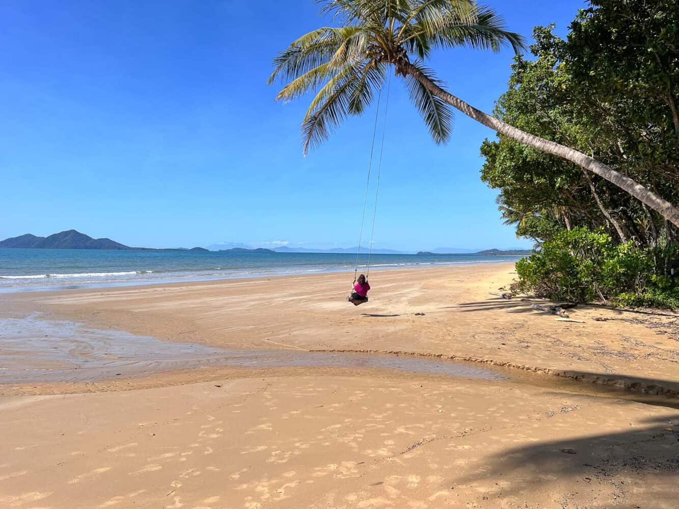 Erin on a swing attached to a palm tree on Mission Beach, North Queensland, Australia