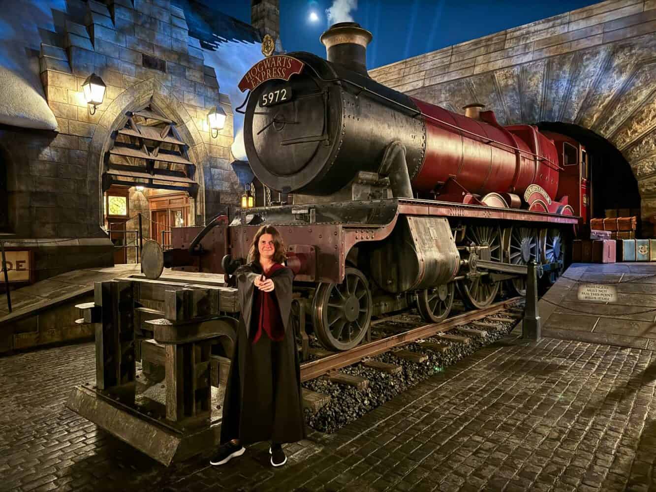 Erin in Gryffindor robe with wand in front of Hogwarts Express at Universal Studios Japan