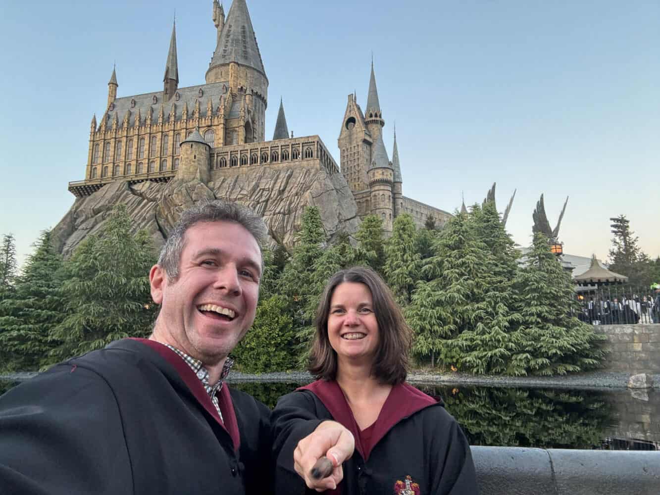 Simon and Erin with gowns and wands outside Hogwarts in Universal Studios Japan