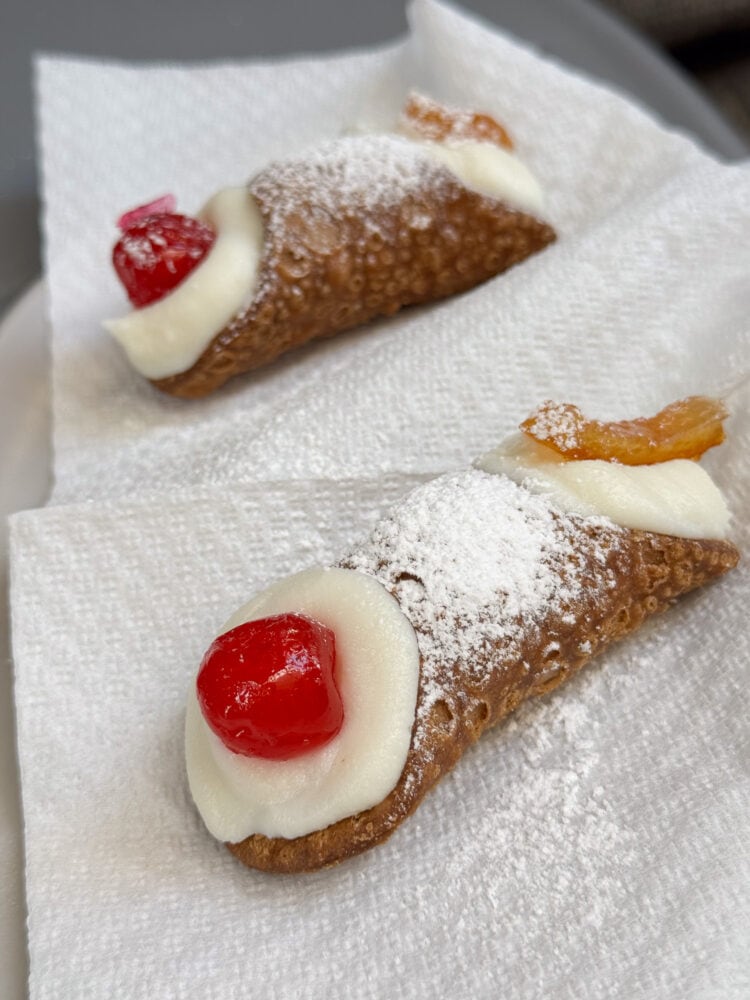 Trying cannoli on a street food tour in Syracuse, Sicily
