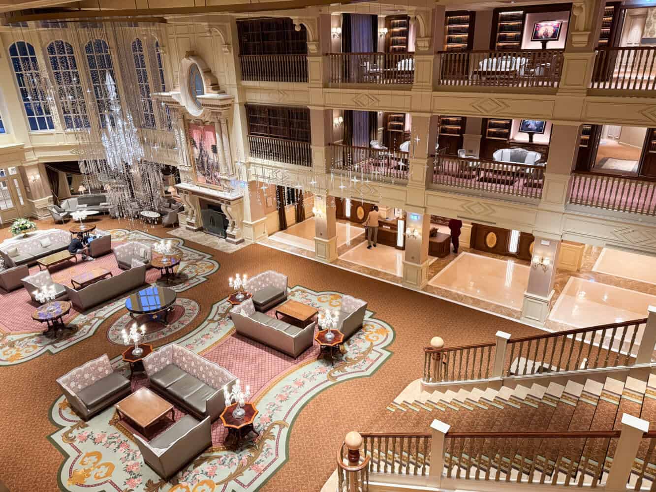 View of the lobby with several seating areas from the staircase at Disneyland Hotel Paris
