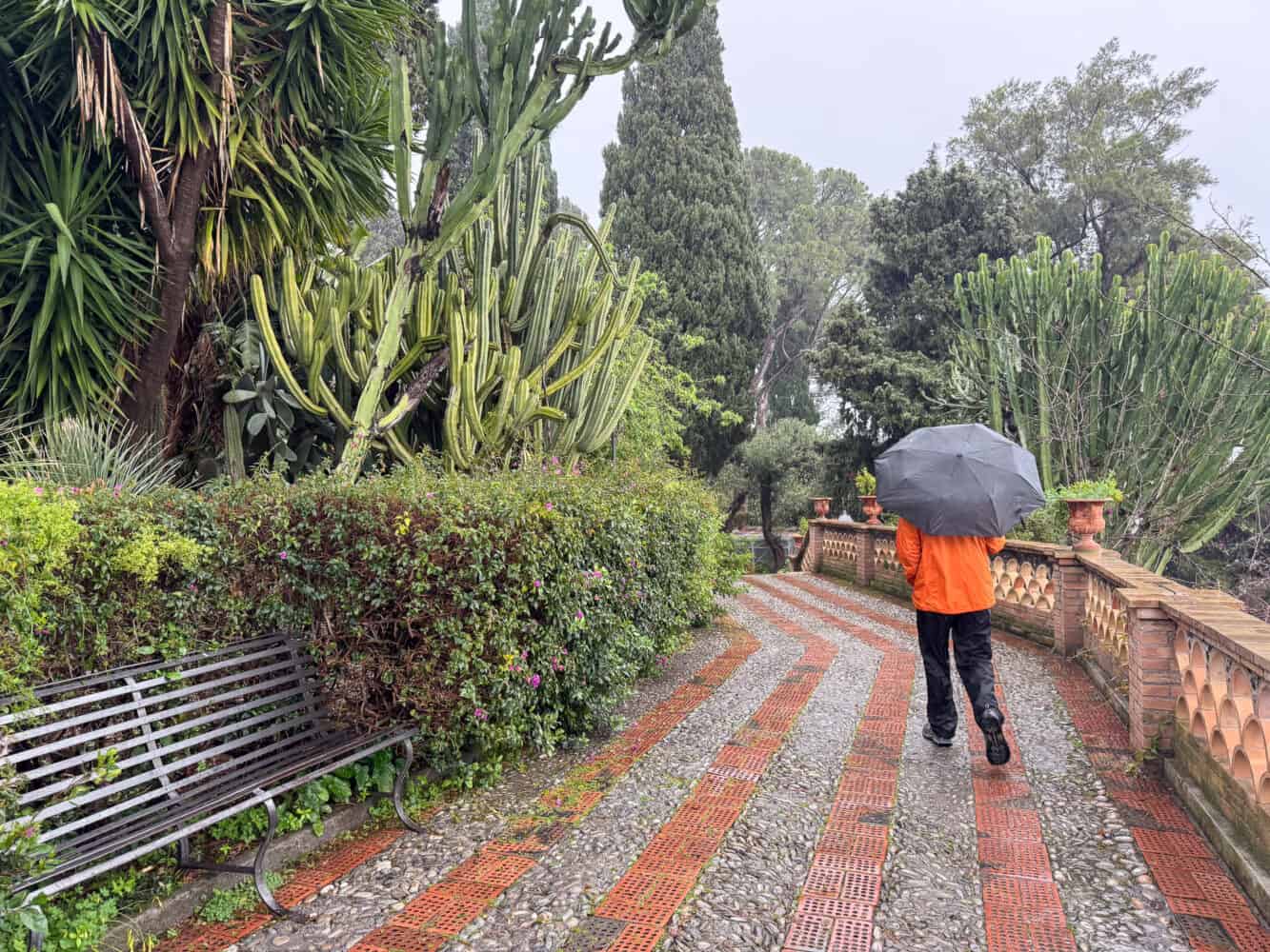 Walking in Vila Comunale public gardens in Taormina, Sicily in the rain.