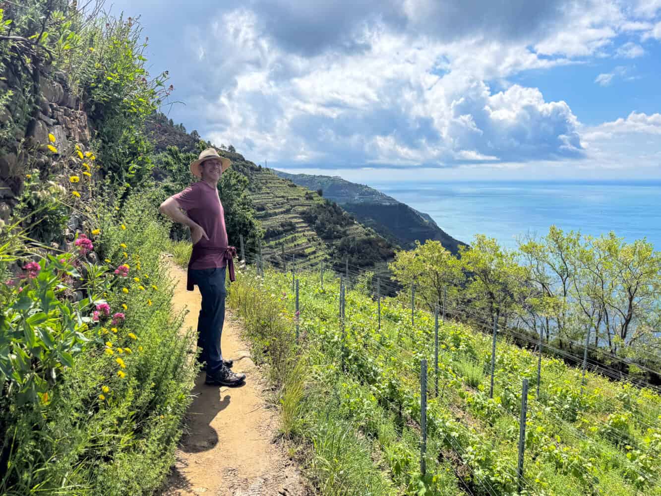 Simon hiking through a vineyard with sea views on the Corniglia to Manarola hike via Volastra in Cinque Terre, Liguria, Italy